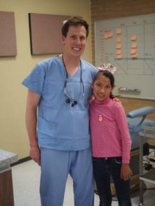 Dr. Moos in powder blue scrubs with a Mexican girl wearing a pink shirt in Puebla, Mexico