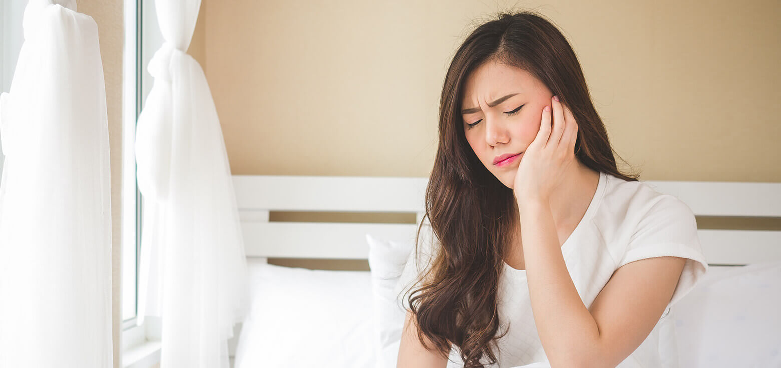 asian woman holding face in pain