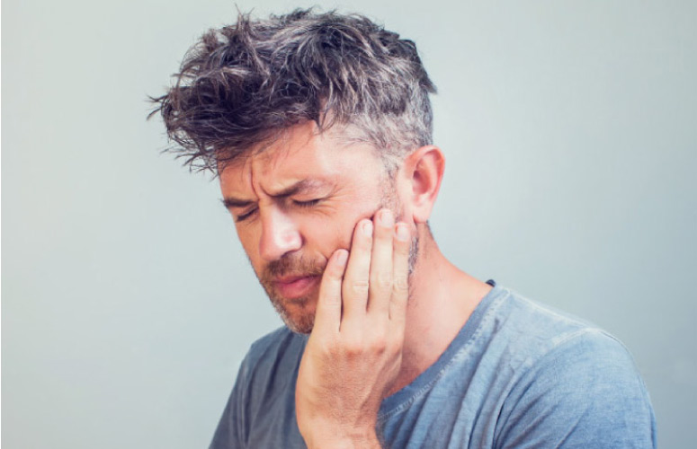 man holding his jaw with a bad toothache