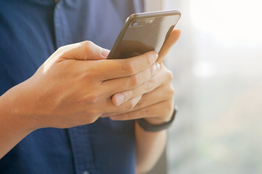 Closeup of hands holding a cell phone looking up coronavirus resources in Eden Prairie, MN