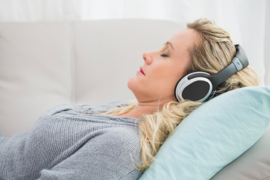 Woman with headphones in the dental chair to handle dental anxiety.