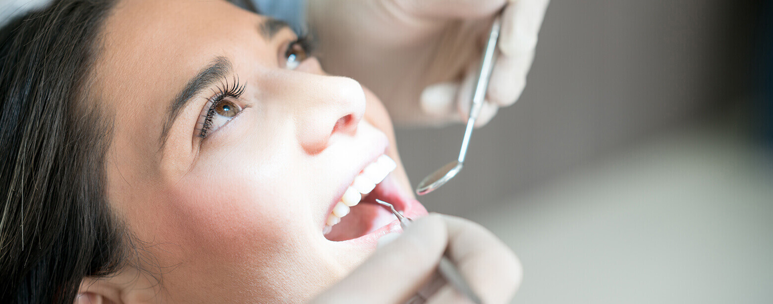 woman having her teeth examined by her dentist