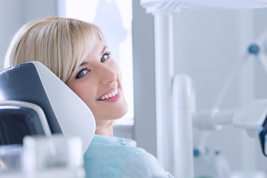 Smiling blond woman in the dental chair.