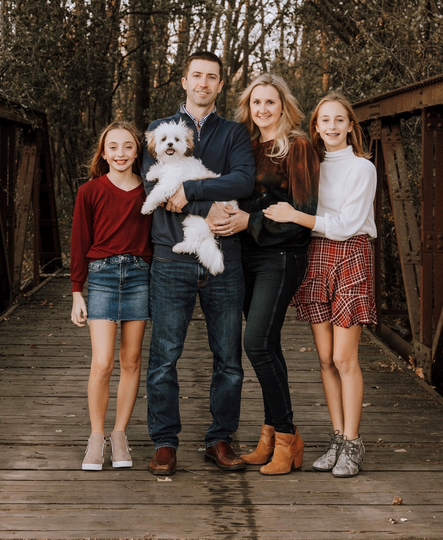 Family smiling with small white dog